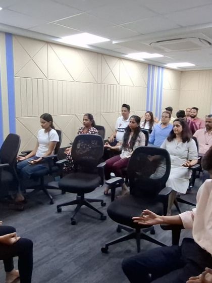 Employees practicing a seated meditation posture during our wellness session. Learning to find stillness amidst the workday can greatly enhance focus and emotional regulation.