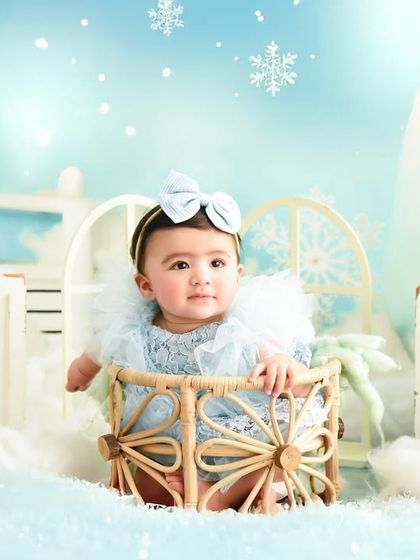 A calm and curious look from a baby in our winter wonderland setup. The soft blues and whites create a serene and beautiful atmosphere.