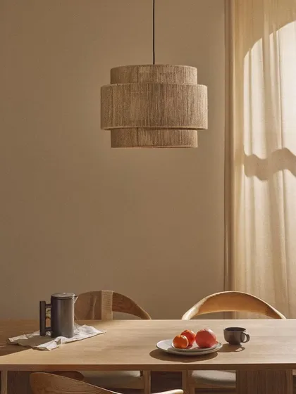 A tiered pendant light wrapped in natural jute fiber. This fixture is perfect for adding a touch of bohemian or coastal style to a dining area.
