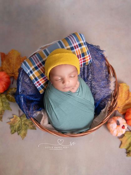 This little pumpkin is the cutest in the patch! The cozy swaddle and plaid pillow make this a perfect and adorable autumn-themed shot.