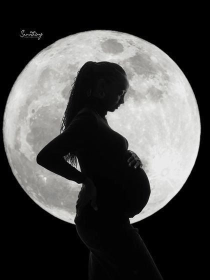 A striking solo silhouette of a mother-to-be against a full moon. Her classic pose and the dramatic lighting create a timeless and powerful image of motherhood.