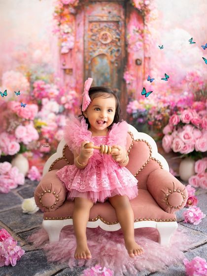 A princess in her pink palace garden. This stunning backdrop, filled with pink blossoms and magical butterflies, creates a true fairytale setting for a first birthday.