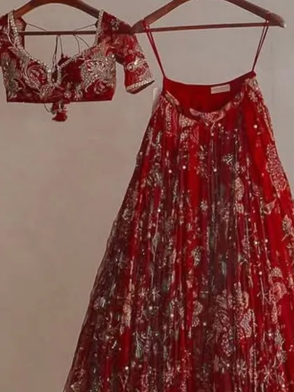 A classic red floral print lehenga. This designer-inspired piece is perfect for any festive occasion, offering a timeless yet fresh look.