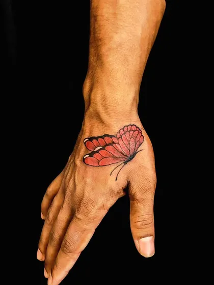 This vibrant red butterfly now sits where an old tattoo used to be. Using color is a great strategy for cover-ups, drawing the eye to the new, beautiful design.