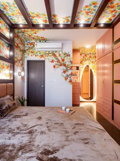 In this master bedroom, I wanted to create an immersive, artistic retreat. A hand-painted mural of autumn leaves flows across the walls and onto the ceiling, framed by wooden beams. This technique brings the beauty of nature indoors, creating a cozy and luxurious escape.