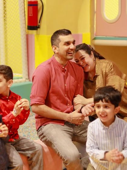 A family enjoys the magic show together, their faces filled with amusement and happiness. Shared experiences like these are what make parties memorable.