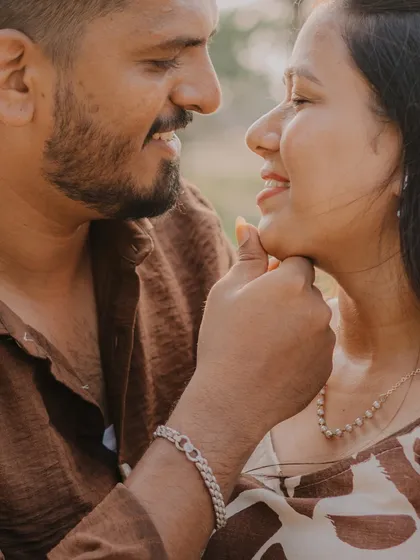 A tender close-up from an outdoor shoot. The groom gently holding the bride's chin creates a very intimate and affectionate moment between them.