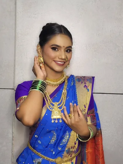 A happy client ready for Gudi Padwa celebrations. The look features a clean, elegant bun hairstyle and makeup that enhances her natural features.