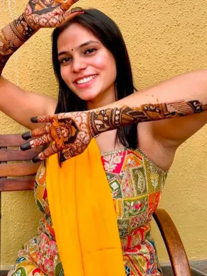 The perfect pose to showcase a full bridal mehandi design.