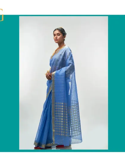 A side view of the cornflower blue saree, showing the delicate checks and the interesting play of geometrics on the pallu.