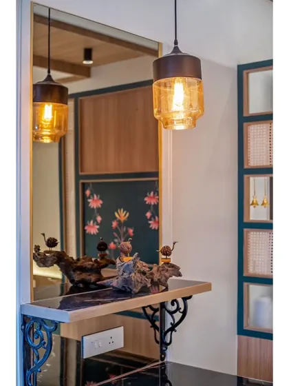 A close-up of the dining table decor and the amber glass pendant lights. These details add warmth and character to the modern dining setup.