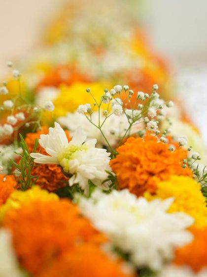 A close-up of the fresh flowers used in our traditional housewarming decor. The vibrant colors of the marigolds and the softness of the baby's breath create a beautiful texture.