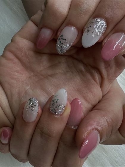 An angled shot that captures the texture of the glitter and the shine of the ombré nails.