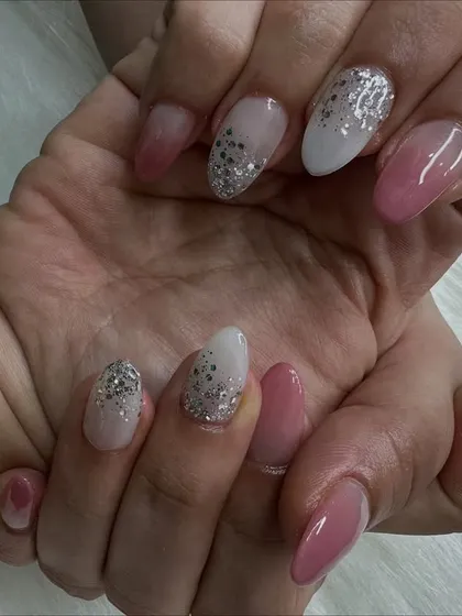 An angled shot that captures the texture of the glitter and the shine of the ombré nails.