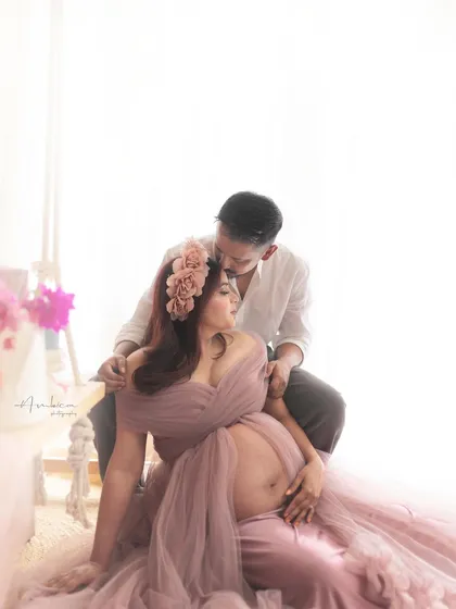 An intimate moment from the same session, with the partner gently kissing her forehead. These unposed, candid shots often become the most cherished memories from a maternity photoshoot.