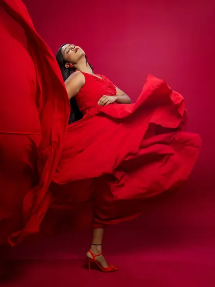 The red dress in full flight. This shot captures the fabric in motion, creating a sense of freedom and high-fashion energy.