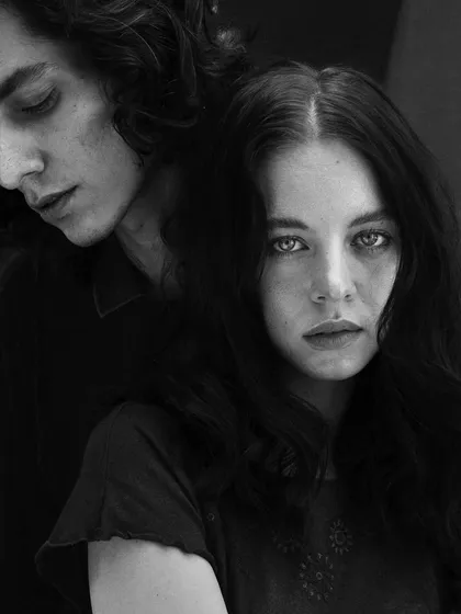 A black and white version of a couples portrait, emphasizing the emotional distance and connection through stark contrast and composition.