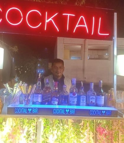 A classic cocktail bar setup with a bright red neon sign, perfect for any celebration.