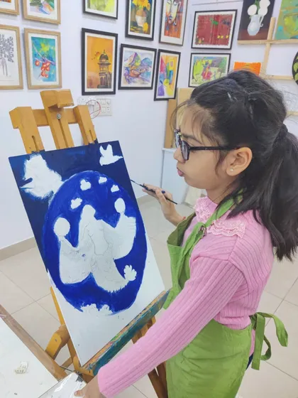 A series showing different students working on and completing a large, imaginative mermaid painting.