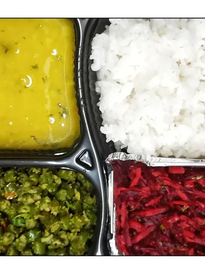 A colorful and nutritious meal platter with dal, rice, a green vegetable preparation, and a vibrant beetroot salad.