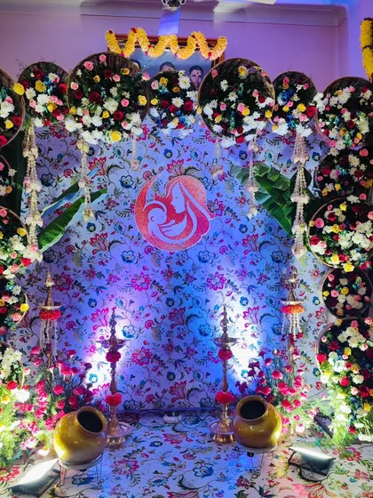 A traditional baby shower decoration set up inside a client's home. We used a floral print backdrop framed with circular arrangements of fresh, colorful flowers to create a warm and blessed space for the mother-to-be.