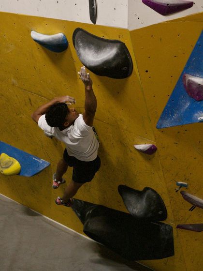 This climber is fully focused, preparing to launch into a dynamic move on an overhanging wall during our Dyno session.