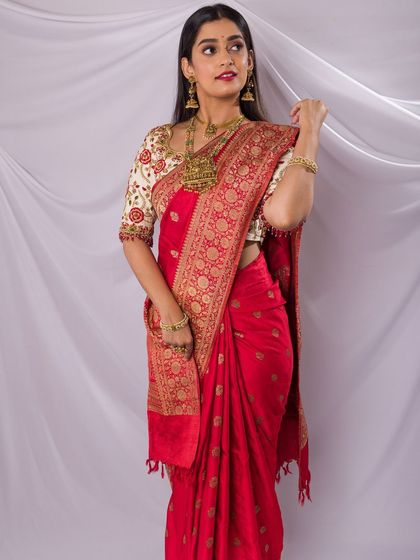A full-length shot from a professional photoshoot for a jewellery brand, showcasing a classic red saree look with my signature soft glam makeup.