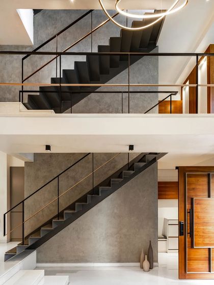 The interior of 'SOL' features a series of folded-plate steel staircases that create a continuous vertical journey through the home. The raw, industrial feel of the steel contrasts with the smooth, plastered walls and warm wood accents.