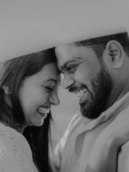 A beautiful black and white close-up, capturing a moment of pure joy and laughter under a veil. This format enhances the emotional intimacy.