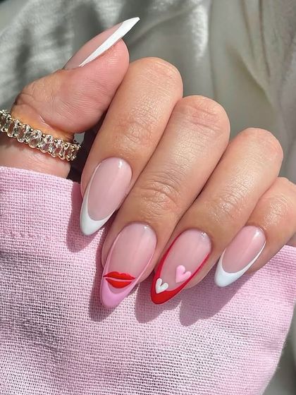 A playful and modern nail art idea for Valentine's Day. This set features a mix of classic white and red French tips with cute, pop-art inspired lip and heart designs.