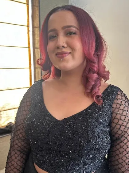 A soft and simple hairstyle with gentle curls for this client. The look is designed to complement her edgy style and brown smokey eye makeup.