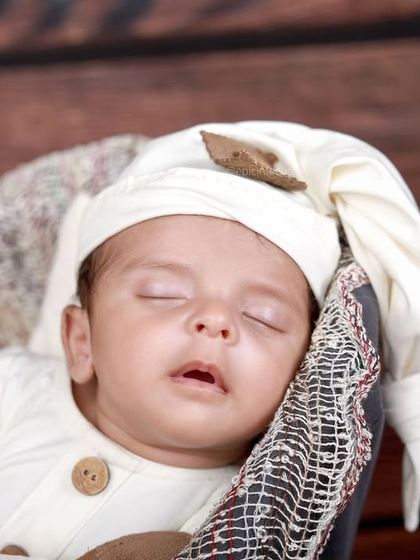 A close-up portrait of the baby's sleepy face from our vintage session. We focus on capturing the peacefulness of a sleeping newborn.