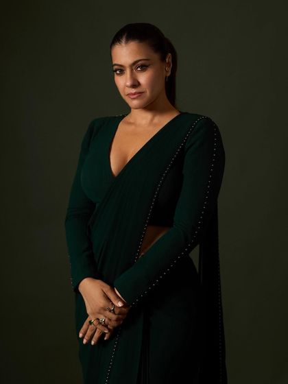 A closer view of the custom draped saree, showing the subtle pearl detailing along the sleeves and the deep V-neckline of the blouse.