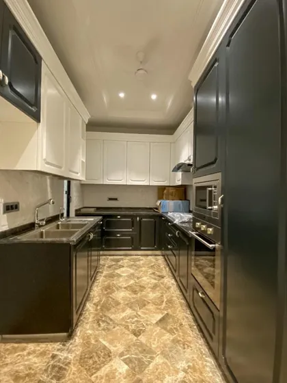This kitchen combines dark lower cabinets with white upper cabinets for a modern, two-tone look. The under-cabinet lighting provides excellent task lighting while adding to the luxurious feel.
