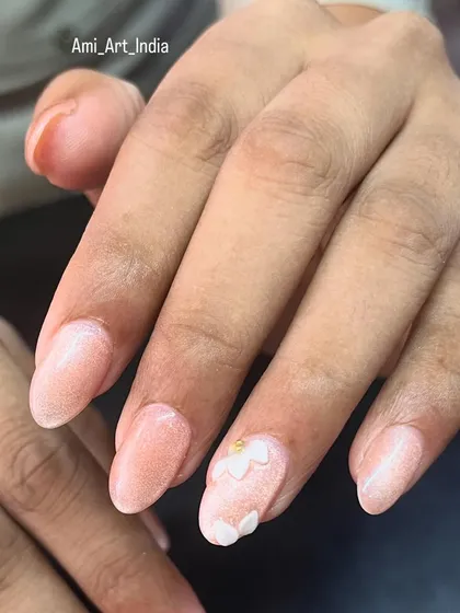 A delicate look with shimmery pink polish and a 3D white flower accent.
