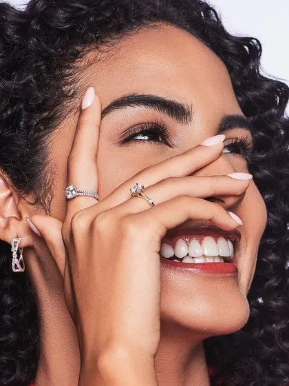 A happy and natural glam look. The makeup enhances her features with a soft contour, groomed brows, and a touch of gloss on the lips, perfect for a daytime event.