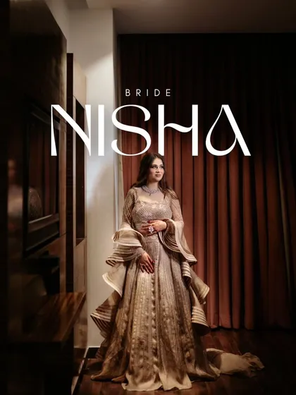 A full-length solo portrait of the bride, Nisha, showcasing her glamorous, ruffled gown against a dark, moody backdrop.