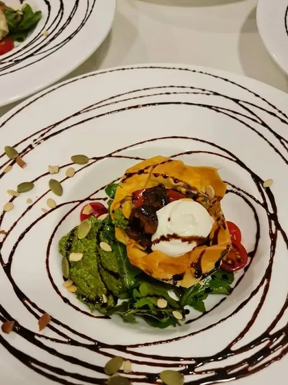A beautifully plated Ratatouille Vol-au-Vent with avocado puree and a balsamic glaze swirl. This dish shows our flair for presentation, turning a classic into a modern culinary creation for a formal dinner.