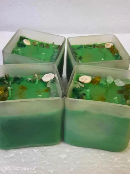 Elegance meets freshness. Our green wax candle in a premium square jar is topped with seashells and crystals for a classy vibe.