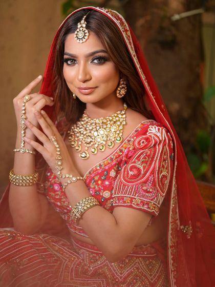 A complete bridal look featuring a heavy, gold-plated Kundan necklace, haath phool, and maang tikka, all available for rent.