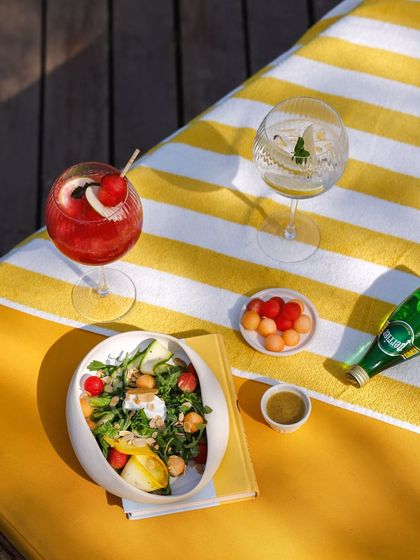 Poolside indulgence with a fresh salad, seasonal fruits, and colorful cocktails, the perfect way to spend a sunny afternoon.