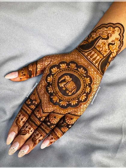 A beautiful back-hand design with a central mandala holding a ceremonial elephant. The use of dark-filled space makes the intricate details stand out.