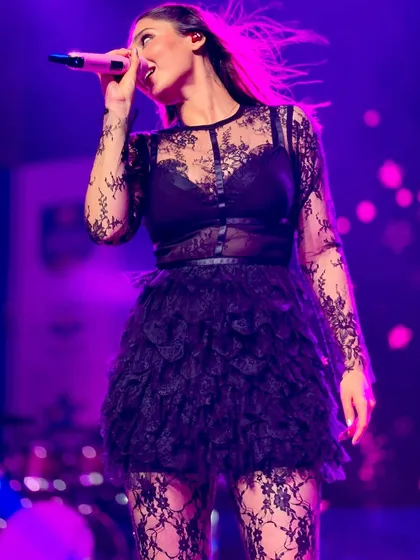 A magical stage moment. Dhvani Bhanushali performs in a custom black lace and tulle outfit from Seraphine Design Studio, set against a dreamy moonlit backdrop.