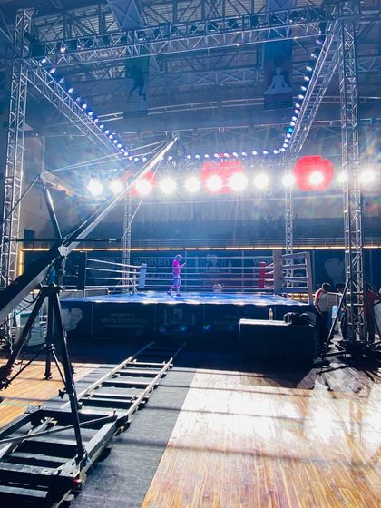 A behind-the-scenes look at the production setup for a boxing championship, including a camera on a dolly track. We accommodate professional broadcast crews and their equipment.