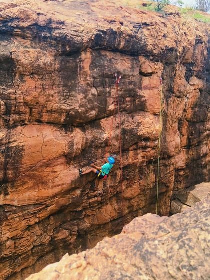A climber rappels into a stunning canyon, showcasing the adventurous descents in Badami.