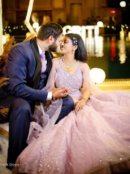 A perfect fairytale moment from an engagement night. The couple shares a sweet, almost-kiss, surrounded by the warm glow of poolside lights, creating a magical and romantic atmosphere.