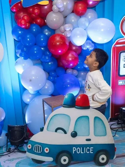 A little guest looking up in wonder at the balloon decor and gas station prop. I design my setups to be magical from a child's perspective.