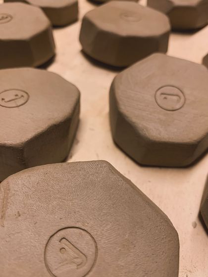 A close-up of the raw, faceted pieces, showing the clean edges and the maker's mark.