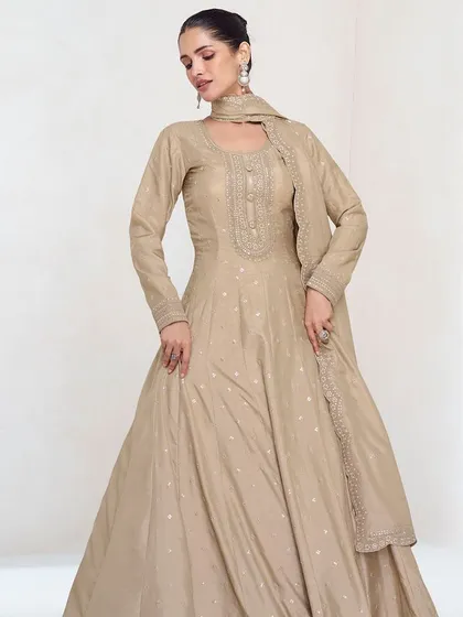This beige premium silk gown is the definition of understated elegance. The delicate thread embroidery and sequins add a touch of sparkle, making it perfect for a reception or evening party.