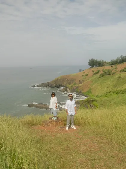 A stunning landscape shot of the couple on a cliff overlooking the Goan coast. It captures the "mountain" feel that the bride wanted for her shoot.
